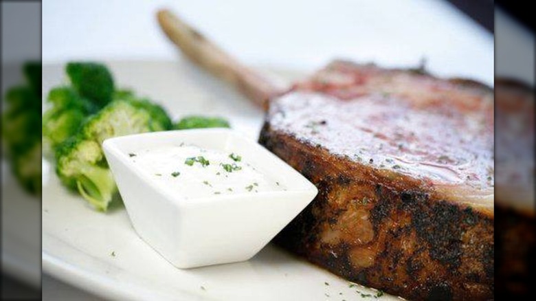 Close-up or prime rib on plate with broccoli and horseradish