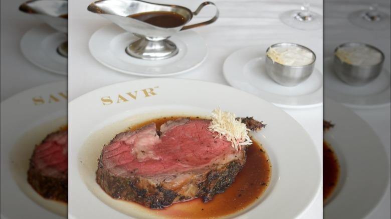 Prime rib on plate with horseradish, grated cheese, and au jus