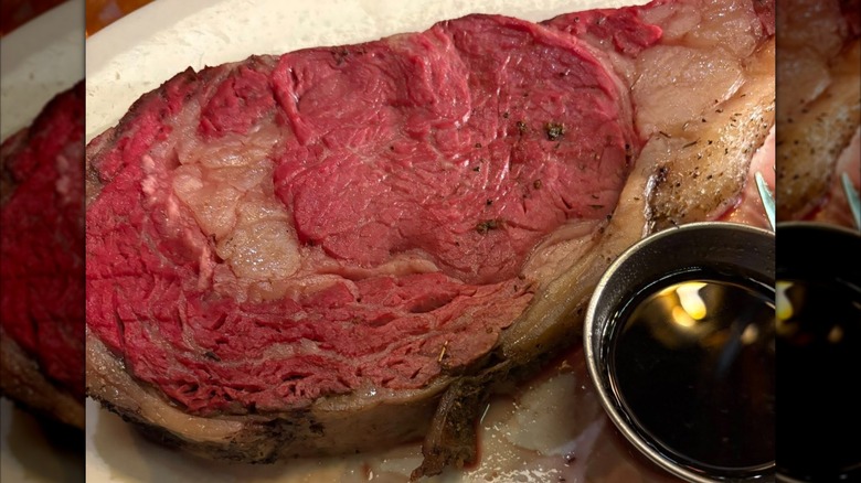 Close-up of prime rib and cup of au jus