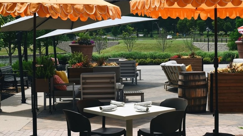Tables on a patio surrounded by gardens