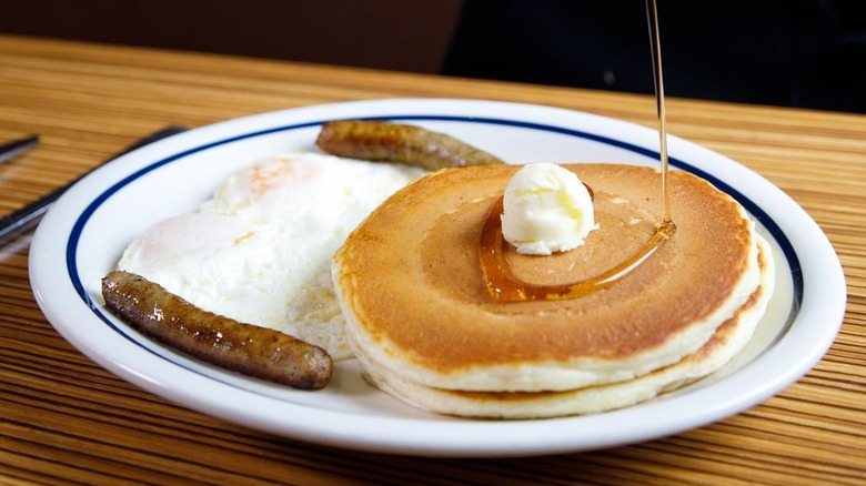 pancake stack with fried eggs and sausage