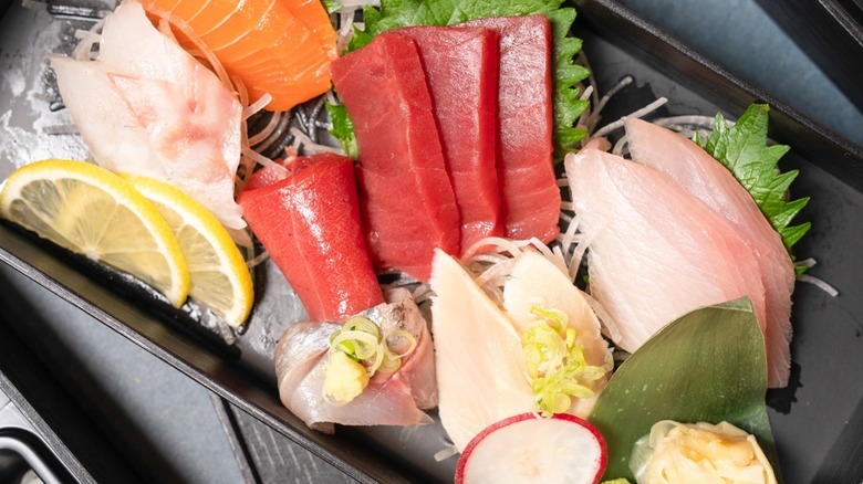 sashimi sushi displayed on black plate