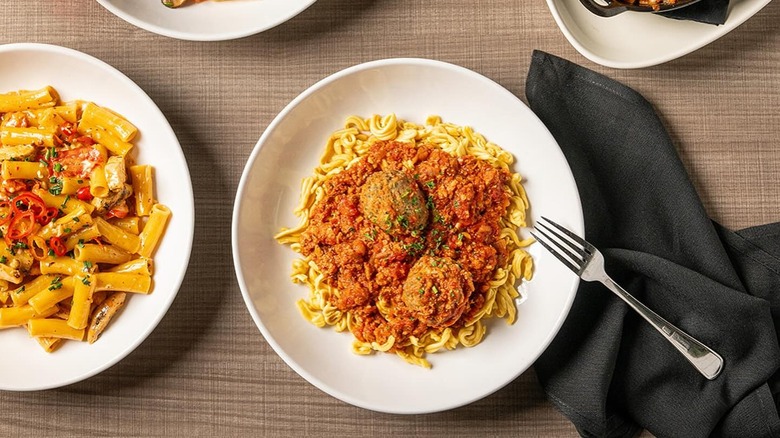 two pasta dishes on white plates