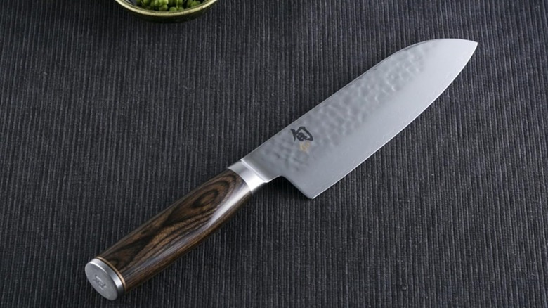 A Shun santoku knife on a black mat