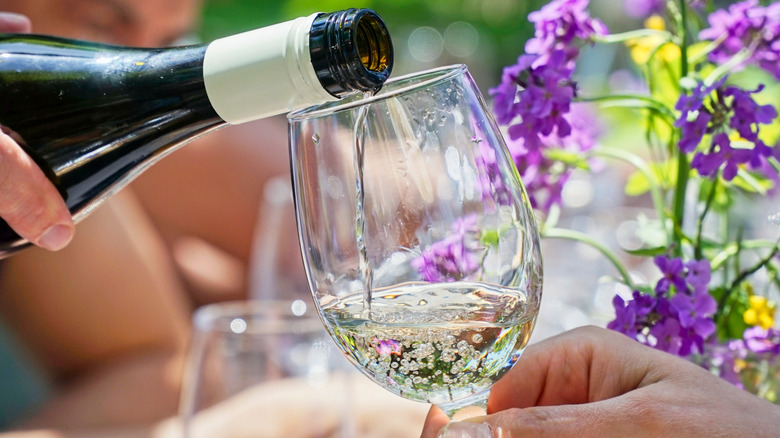 pouring white wine into glass