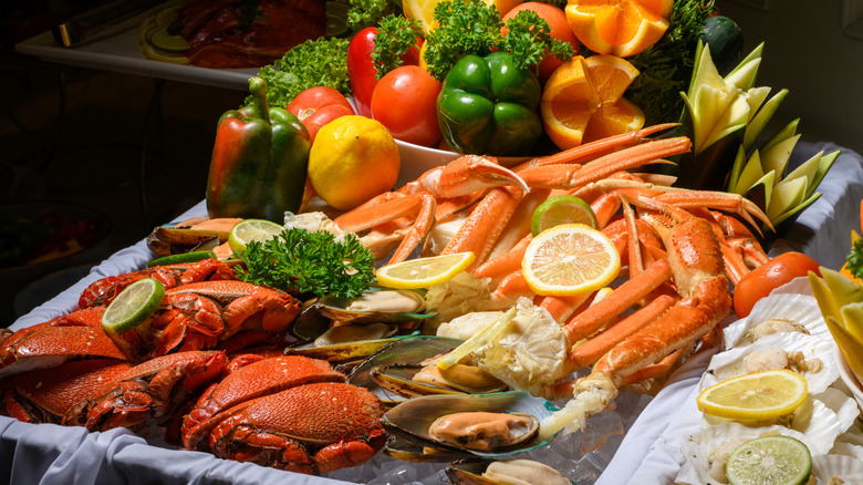Elegant display of crab, oysters, and clams with lemon and orange wedges and veggies