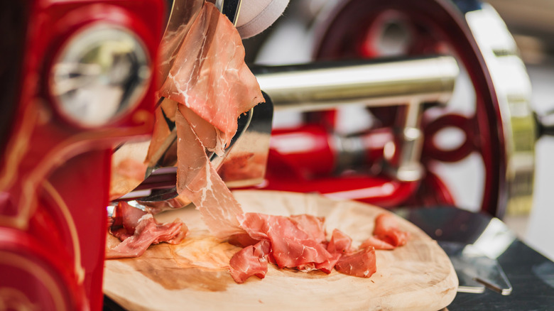 Deli slicer cutting cured meats