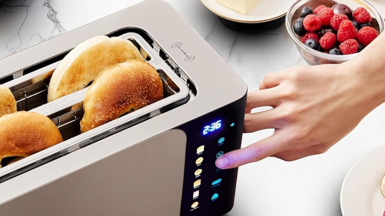 A person setting an Elite Gourmet toaster