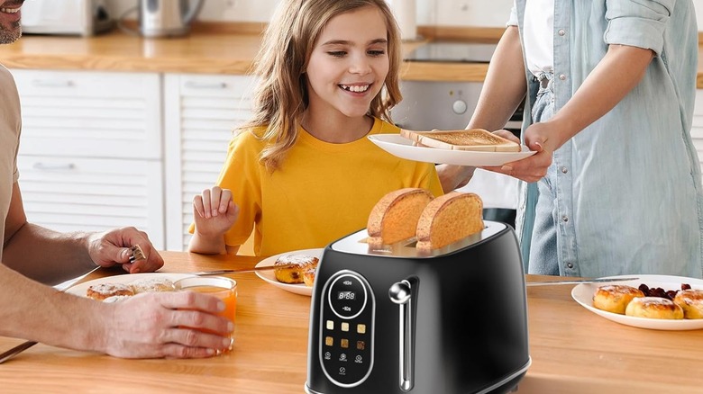 A mother and daugher getting toast from a Keenstone toaster