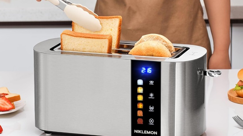 A person pulling toast out of a Niklemon toaster