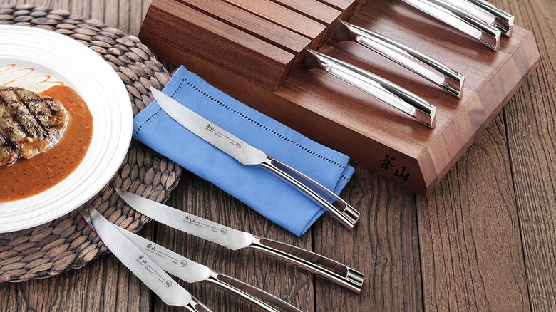 Cangshan N1 Series 8-Piece Steak Knife Set in a wooden block next to a meal