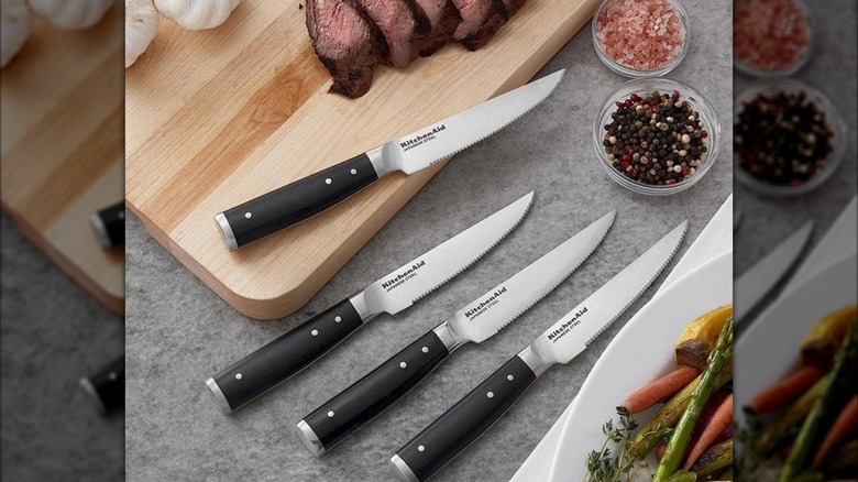 KitchenAid Gourmet 4-Piece Steak Knife Set on a table with dishes and ingredients