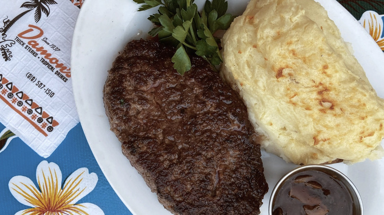 Hamburger steak with gravy and a roll