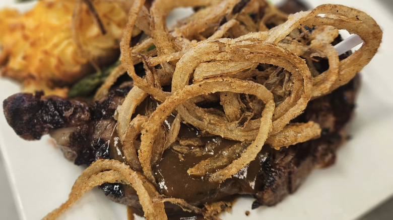 Ribeye steak with fried onions on plate