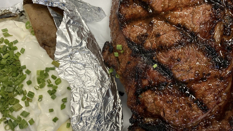 Grilled steak and baked potato on a plate
