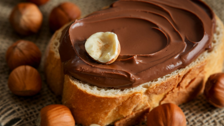 Chocolate hazelnut spread over a slice of white bread