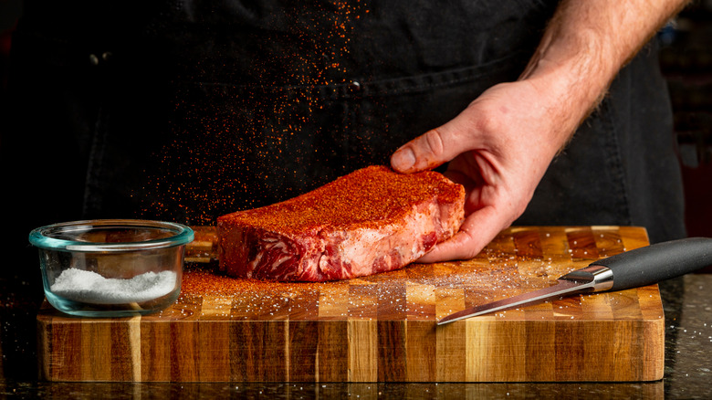 Man shaking steak rub