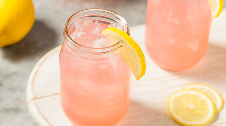 Glasses of strawberry lemonade garnished with lemon wedge