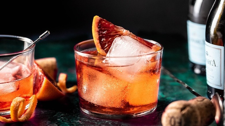 Negroni sbagliato cocktail in glass with ice cubes and slice of blood orange