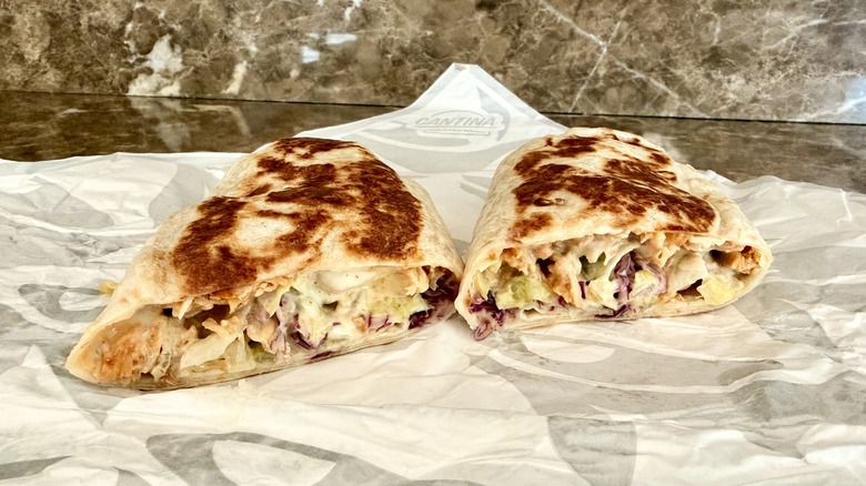 The Cantina Chicken Burrito cut in half on paper