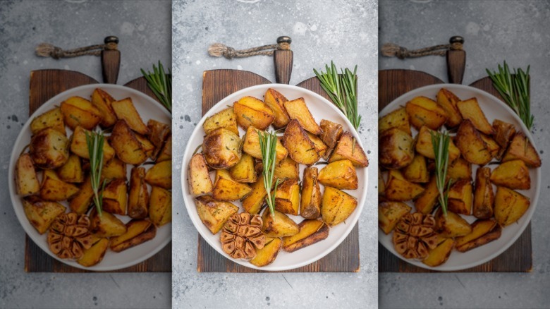 Crispy roasted potato chunks in a bowl with fresh rosemary sprigs