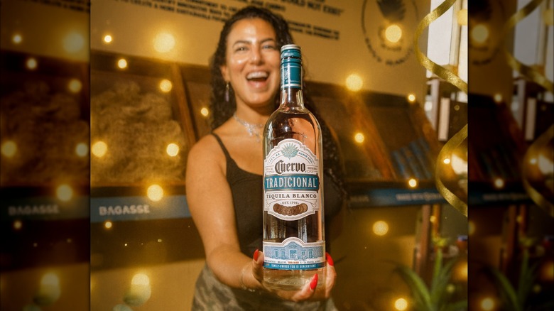 Woman holding a bottle of Cuervo blanco