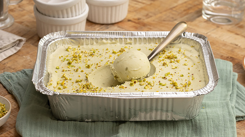Pistachio ice cream in loaf pan with scoop on spoon