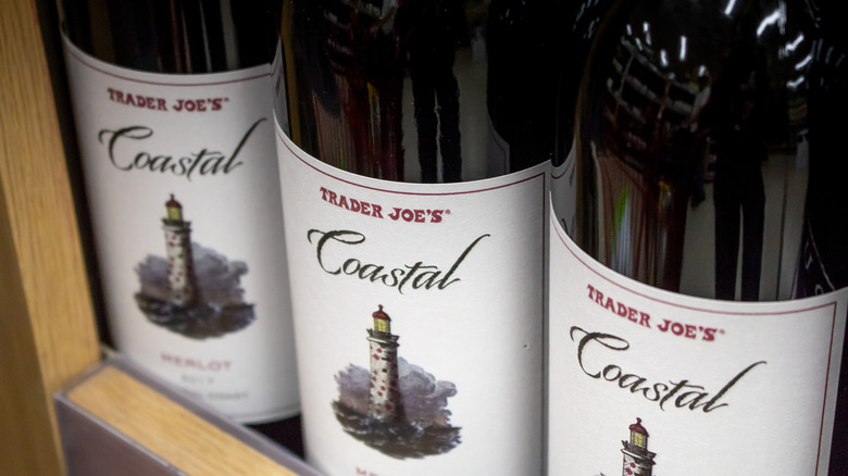 A close-up of three bottles of Trader Joe's Coastal Merlot on a shelf