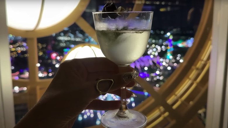 drink held up to window at Bar Helios