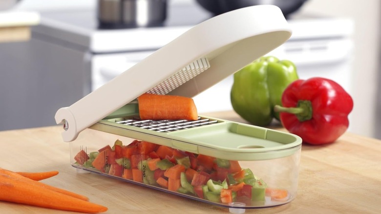 A Vidalia Chop Wizard on a counter with carrots and peppers