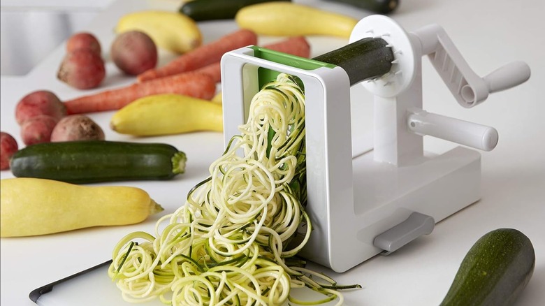 An OXO Good Grips Tabletop Spirlizer cutting zucchini