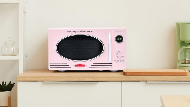Nostalgia Compact Countertop Microwave in pink on a kitchen counter