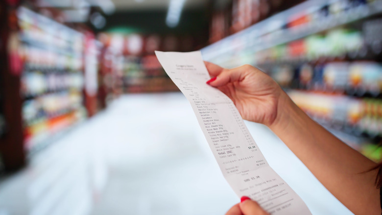 person looking at grocery bill