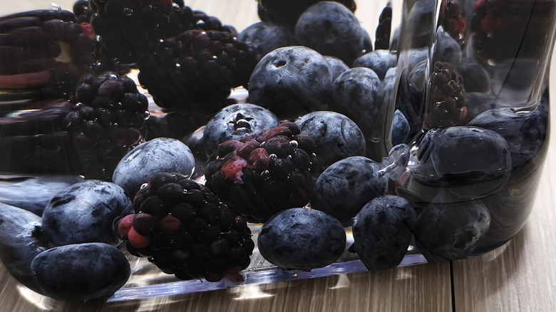 Fresh blackberries and blueberries submerged in water