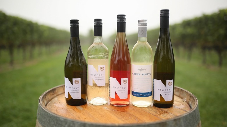 Five bottles of Newport Vineyards wine on a barrel in the vineyard.