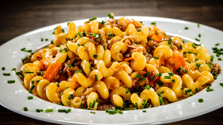 cavatappi pasta with beef in white bowl