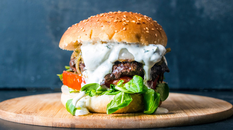 Burger with tzatziki sauce and fresh tomatoes