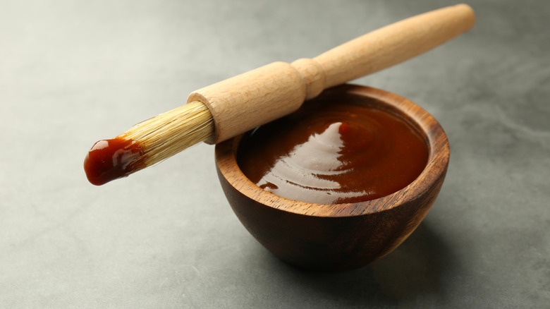 Bowl of barbecue sauce with a brush resting on top