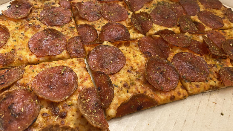 Pizza Hut pepperoni pizza cut into squares dusted with Hut Dust seasoning mix