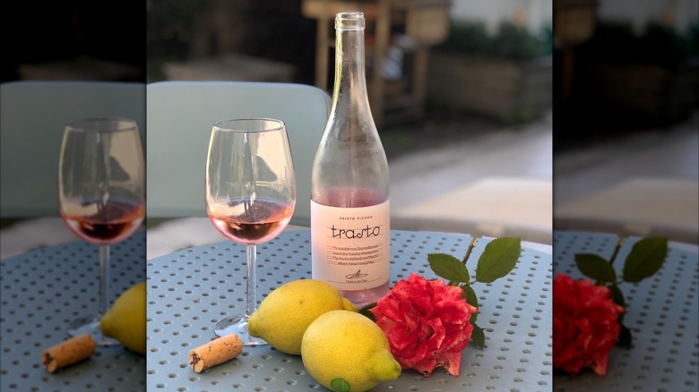 Bottle and glass of Trasto rosé with lemons and rose