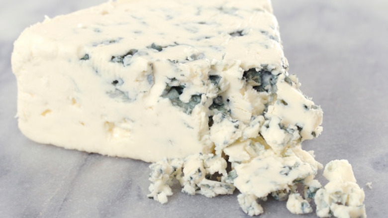 Partially crumbled wedge of blue cheese