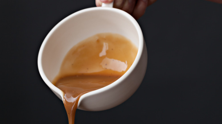 Pouring gravy from white jug