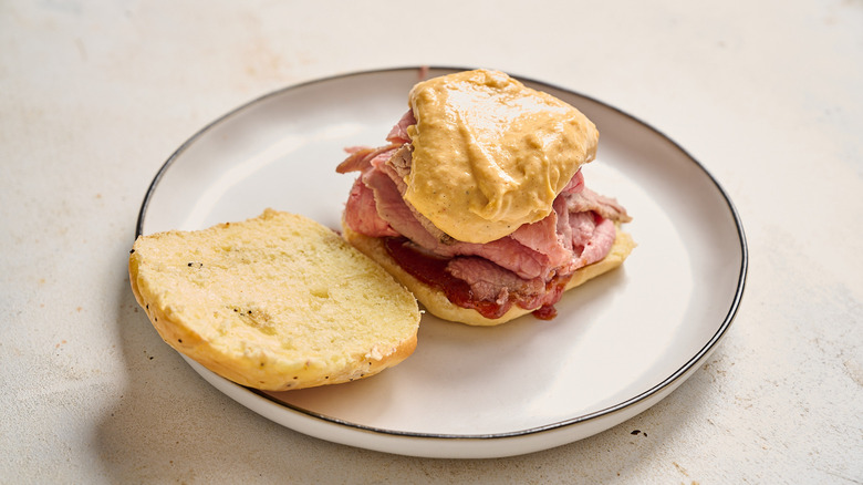 covering beef sandwich with cheese