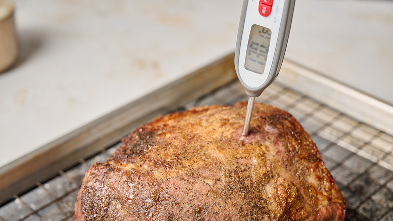 meat thermometer inside of roasted beef