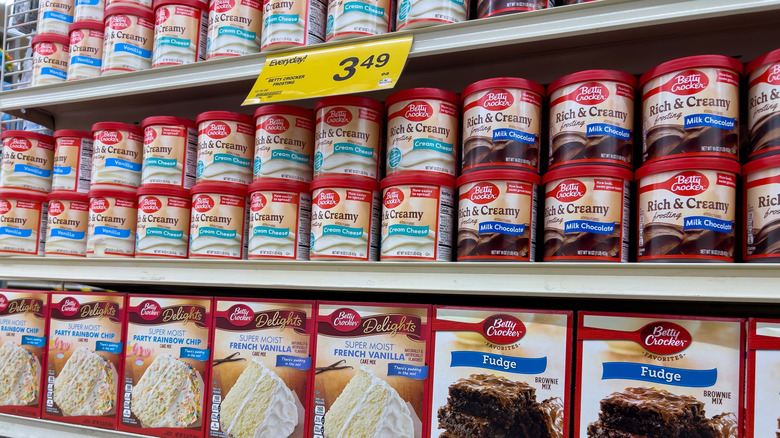 Grocery store shelf with several boxes of Betty Crocker cake mixes and frosting