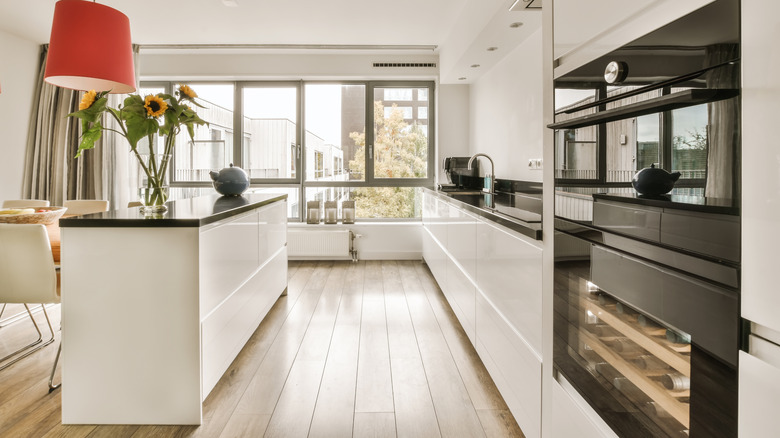 An open floor plan kitchen with a long, narrow galley island separating the kitchen from the eating area