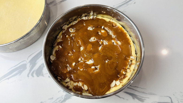 Caramel topping drizzled over almonds and dough