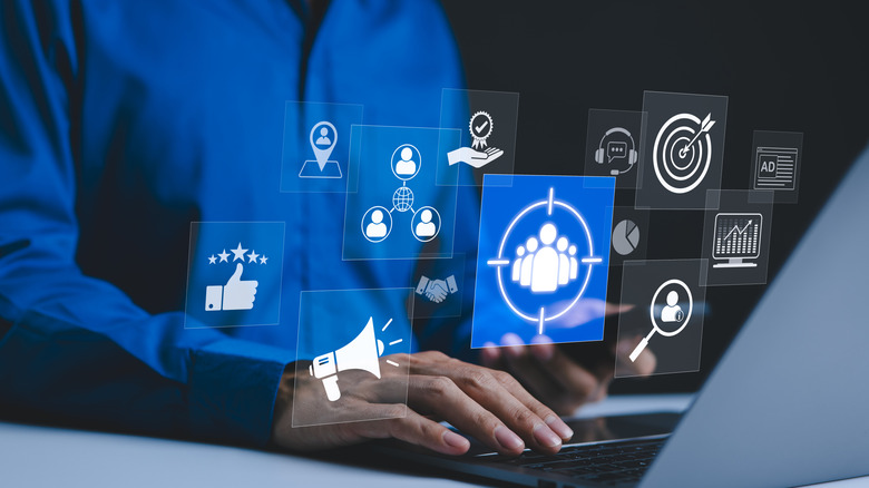 Man on laptop with various marketing icon popups