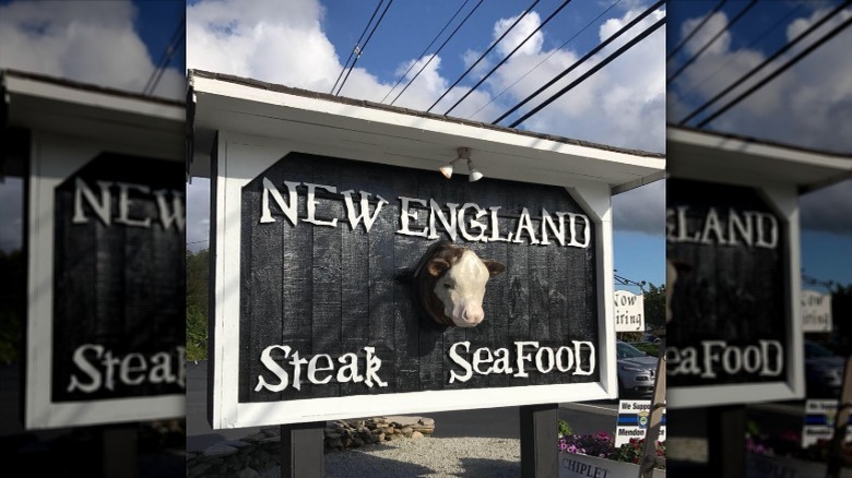 The exterior sign for the New England Steak and Seafood Restaurant