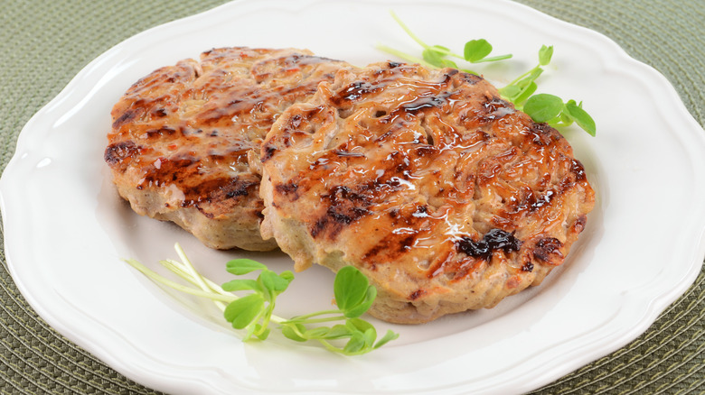 turkey burgers with garnish on white plate